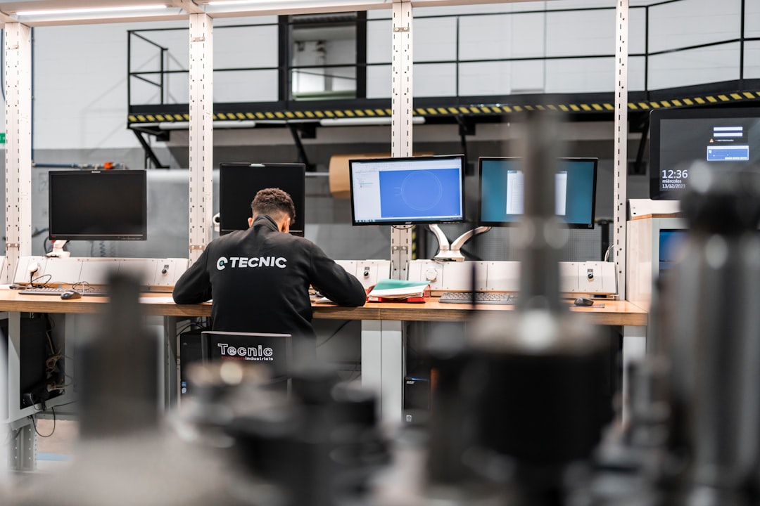 Mechanical engineer working on a parametric 3D model at a CAD workstation — comparing FreeCAD and Fusion 360